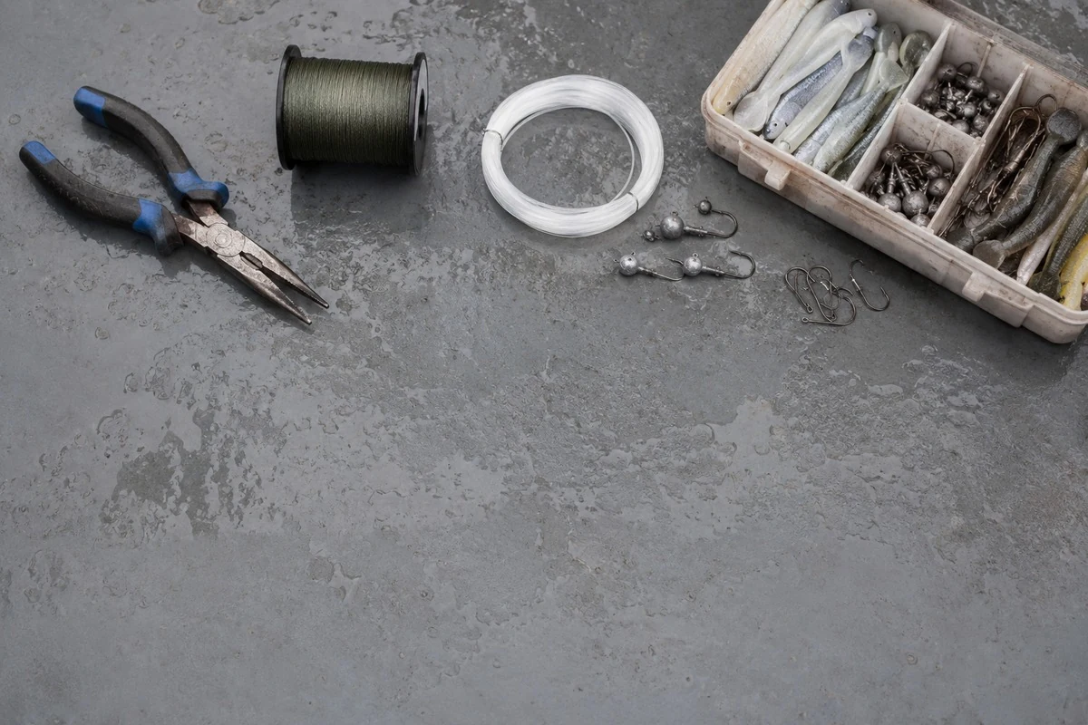 An overhead flat lay of fishing pliers, braided line, leader and terminal tackle