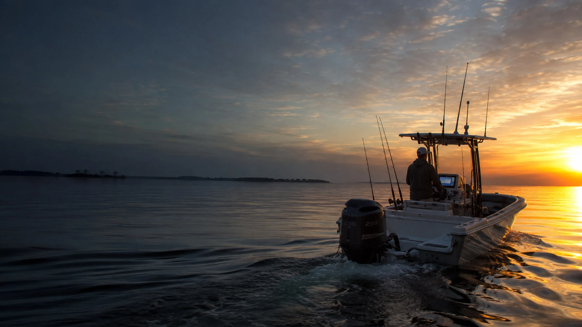 A saltwater fishing boat at sunrise on calm open water