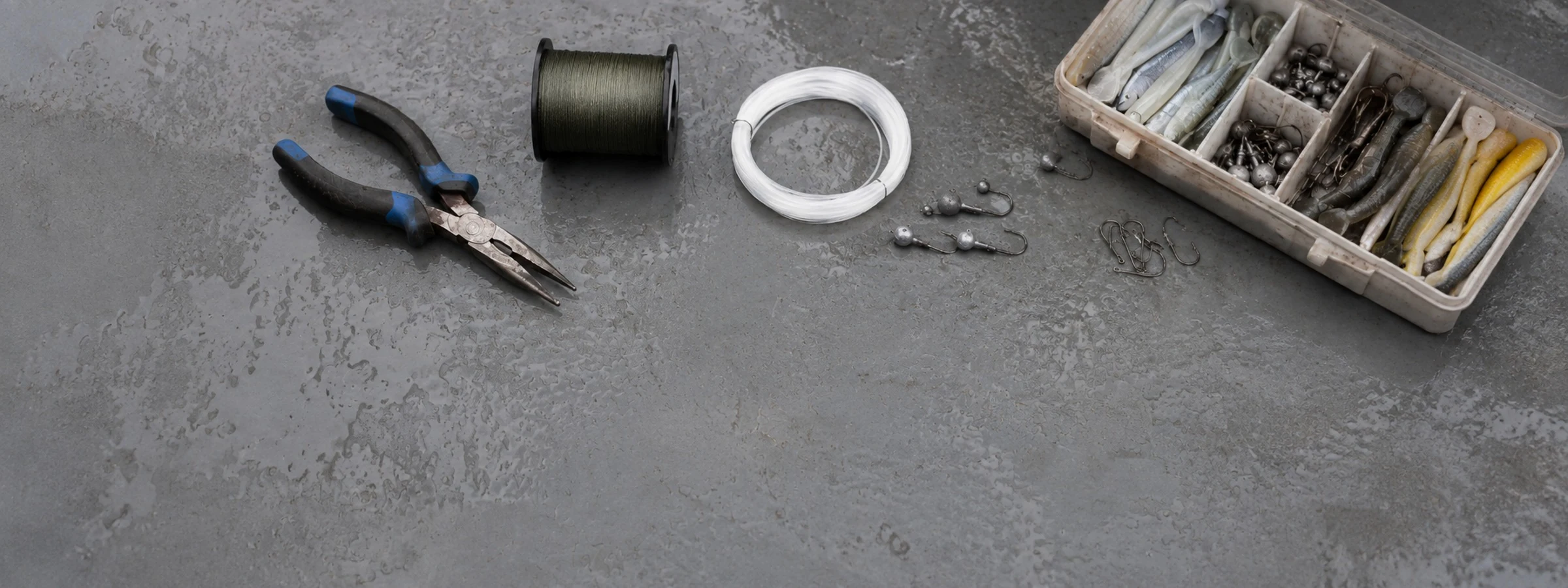 An overhead flat lay of fishing pliers, braided line, leader and terminal tackle