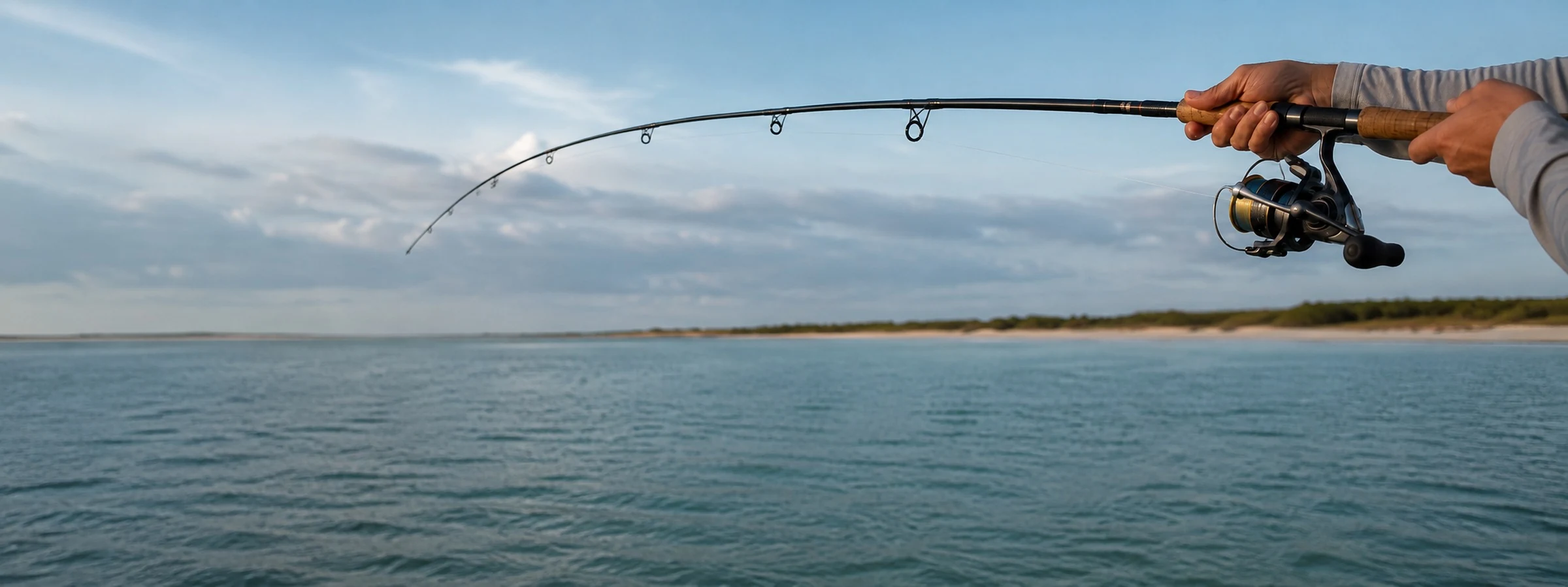 A saltwater spinning rod loaded and bent against open water